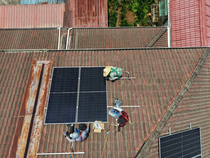 Lava Solar technician installing solar panels on a rooftop in Kuching
